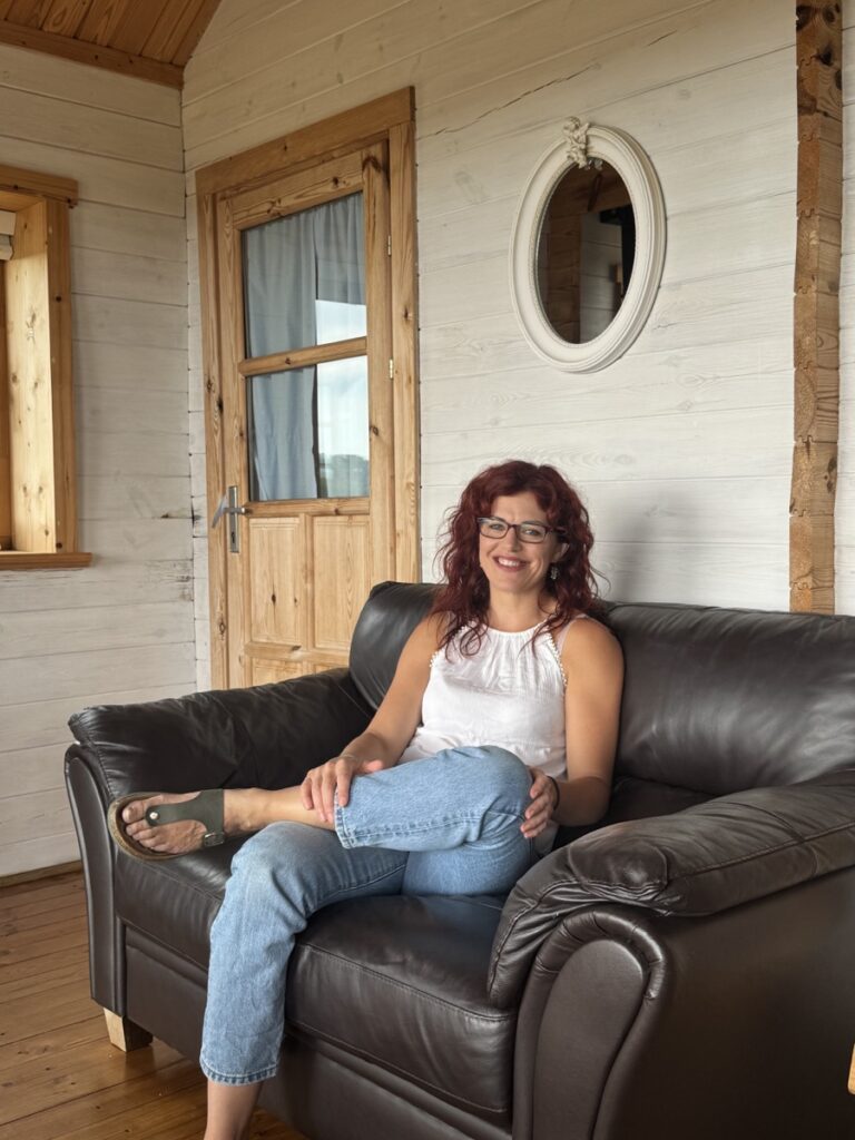 Chloe seated in a quiet wooden cabin